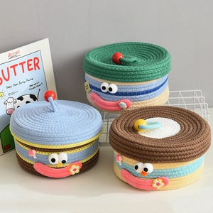 Close-up of woven cotton storage baskets with cute cartoon faces and sphere handles