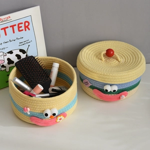 Detail of woven cotton storage baskets with cute cartoon faces and vibrant colors