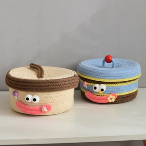 Detail of woven cotton rope baskets with cartoon faces and decorative lids for home storage