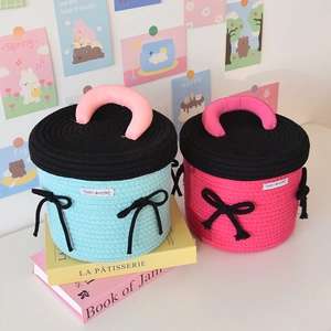 Detail of woven rope storage basket with round lid and decorative bow handle
