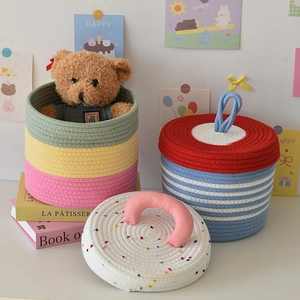 Detail of colorful woven cotton rope storage baskets with lids and handles for kids room