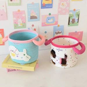 Detail of woven cotton storage baskets with cute puppy patches and soft tubular handles