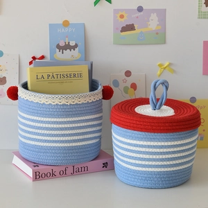 Detailed texture of blue and white woven storage basket with red lace and pompom trim