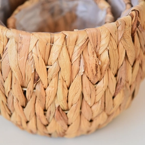 Close-up of handwoven water hyacinth planter showing waterproof clear plastic lining details