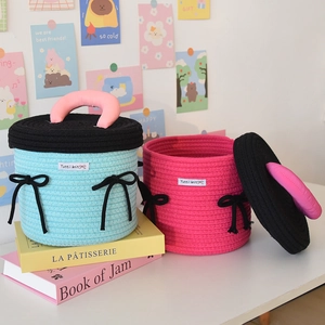 Detailed close-up of handmade cotton rope woven storage baskets with silk bows and lids
