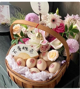 Detailed view of woven flower basket with red Xi character eggs and floral arrangement