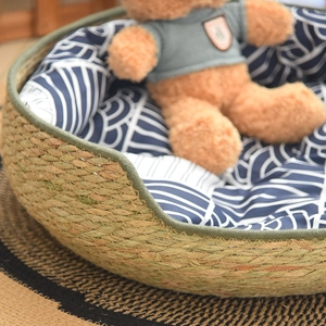 Detail of hand-woven straw pet bed with wave-pattern cushion for cats and small dogs