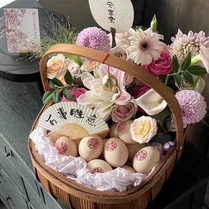 Handcrafted woven bamboo flower basket with eggs and floral arrangement for traditional gifts