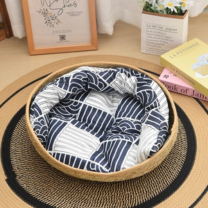 Detailed top view of a hand-woven round cat bed with a blue patterned soft cushion