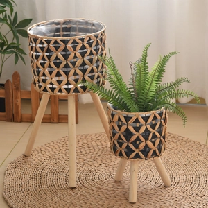 Detail of hand-woven plant stand set with natural grass texture and wooden tripod legs