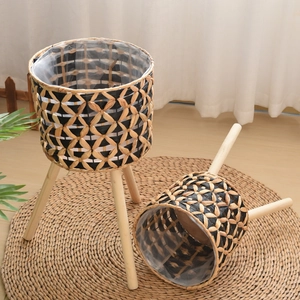 Detail of hand-woven seagrass planter with natural wooden legs and waterproof liner