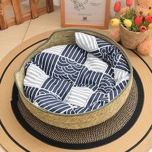 Detail of hand-woven cattail grass cat bed with blue geometric pattern cushion