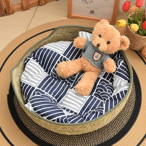 Close-up of a hand-woven straw pet bed featuring a blue and white patterned cushion