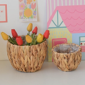 Close-up of woven straw plant pot with transparent waterproof liner and artificial tulips