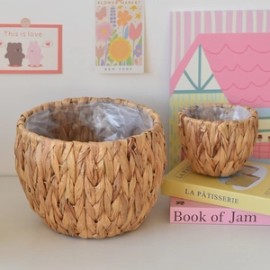 Detail view of woven straw planters with waterproof plastic liner for indoor greenery