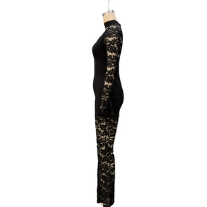 Detail of elegant black lace jumpsuit with floral hollow-out patterns and flared sleeves