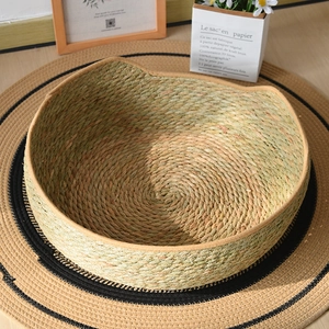 Detail of hand-woven cattail grass cat bed showing natural texture and cat ear accents
