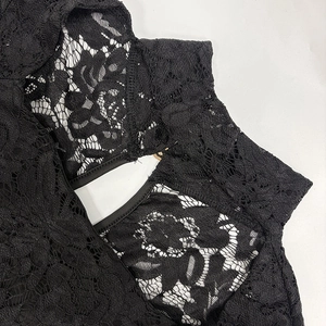 Close-up detail of black floral lace fabric with intricate cutout patterns and smooth edges