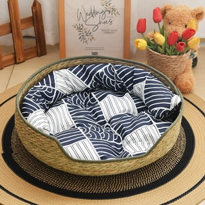 Handwoven round straw pet bed with a blue and white wave pattern cushion for cats and dogs