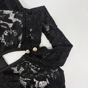 Detailed view of floral lace fabric with gold buttons on this black chic jumpsuit