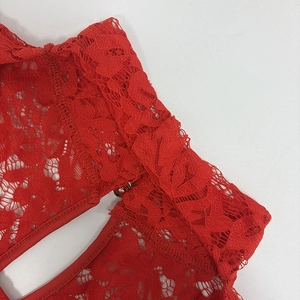Close-up of red floral lace fabric with small metal hook closure detail on a jumpsuit