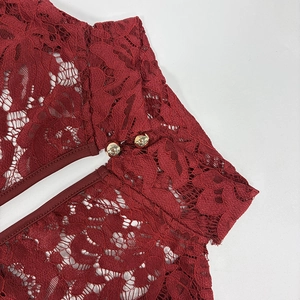 Detailed macro view of wine red floral hollow lace fabric with elegant gold round buttons