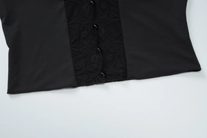 Detail of delicate black lace fabric with elegant pearl buttons on the cardigan top