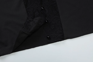Detail of delicate black lace trim and three glossy spherical buttons on a cardigan top