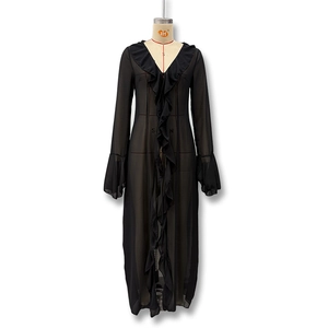 Detail of sheer black chiffon maxi dress featuring ruffled neckline and bell sleeves