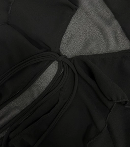 Detail of black chiffon fabric with fine stitching and parallel tie-up strings