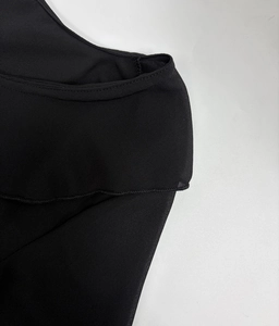 Detail view of lightweight black chiffon fabric with precision hemmed edges on a dress