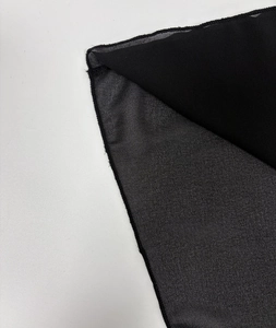 Close-up of semi-transparent black chiffon fabric with delicate lace edges and texture