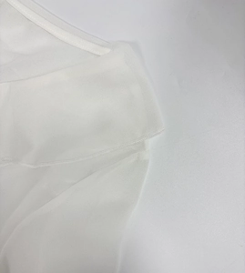 Detail of white semi-transparent chiffon fabric with fine stitching and soft matte texture