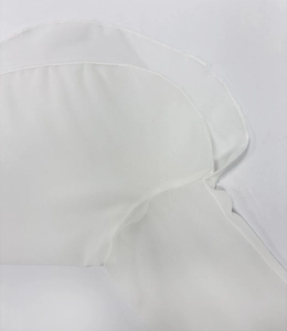 Close-up of white sheer chiffon fabric showing high-quality overlock stitching details