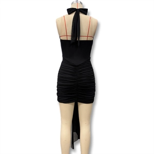 Detail of a black backless halter dress featuring elegant ruching and a bow tie closure