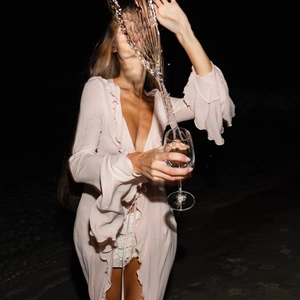 Detail of light pink ruffle cardigan featuring a deep V-neckline and tie-front closure
