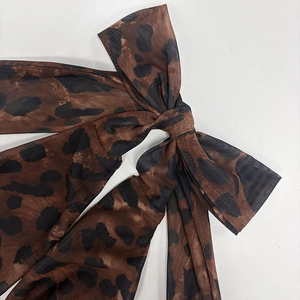 Close-up of leopard print mesh fabric detail with a bow-knot tie on a slim-fit dress