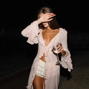 Close-up of pink sheer lace cardigan with ruffled edges and tie-front for beach vacation