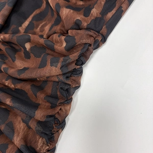 Detail of sheer leopard print mesh fabric with side ruching and intricate patterns
