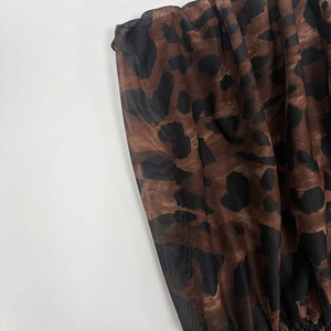 Detail of leopard print mesh fabric with soft ruched texture and translucent mesh pattern