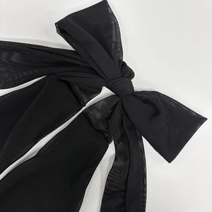 Detailed close-up of a black mesh bow accessory with delicate semi-transparent texture