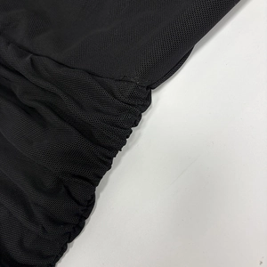 Detail view of the black ruched mesh fabric showing semi-transparent pleated texture