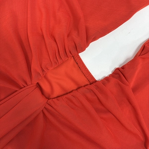 Detail of red mesh fabric with gathered stitching and lightweight honeycomb texture