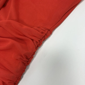 Macro detail of red sheer mesh fabric with elegant ruched texture and fine pleats