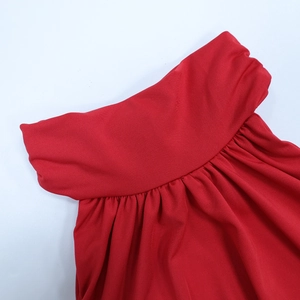Dettaglio dell'abito rosso slim fit con texture a pieghe e tessuto in maglia fine a coste
