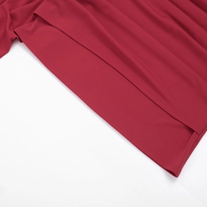 Détail de l'ourlet de la robe rouge foncé avec double couture et texture de tissu fine