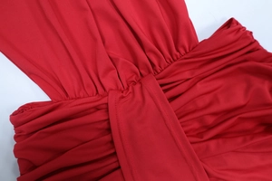 Dettaglio dell'abito a sirena rosso con tessuto arricciato e ampia cucitura decorativa