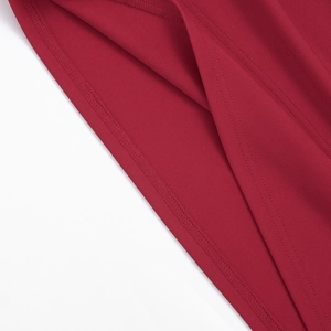 Vue détaillée de la double couture et de la texture du tissu fin sur l'ourlet de la robe rouge