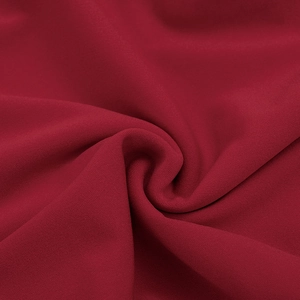 Gros plan sur la texture du tissu rouge foncé avec maille lisse et plis drapés