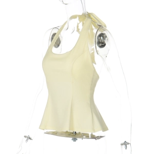 Detail view of a pale yellow halter neck top with peplum hem and back tie design